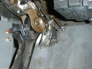 The end of the parking brake release cable housing secured in the bracket