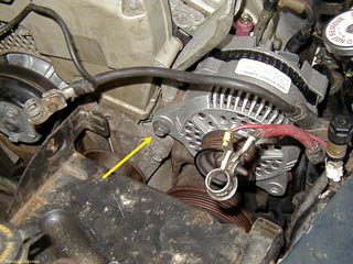 New alternator in place. Arrow points to long bolt holding the alternator.